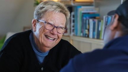 Kvinna med glasögon som ler.