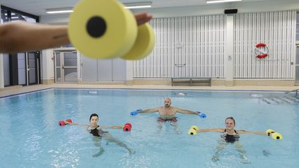 Tre personer deltar i vattengymnastik