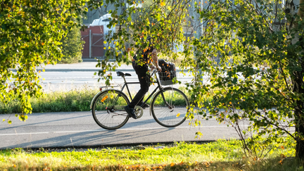 Tjej på cykel som syklar på en cykelbana