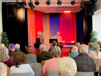 På scenen spelar en man gitarr