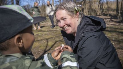 Person får vitsippor av en annan person