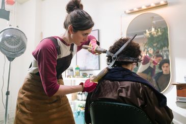 Ett kaosartat konditorikök där en man står och skyfflar mjöl i en cementblandare och kvinnan bredvid hon försöker dekorera en tårta.