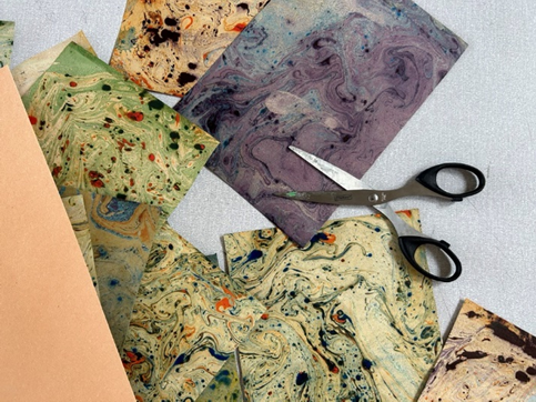 Färgglada papper och en sax på ett bord