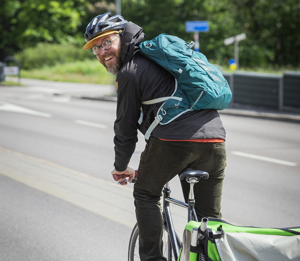 Person som cyklar och tittar bak över axeln på kameran.