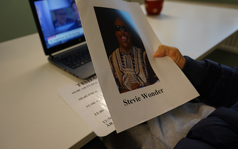 En bild på artisten Stevie Wonder och en datorskärm i bakgrunden.