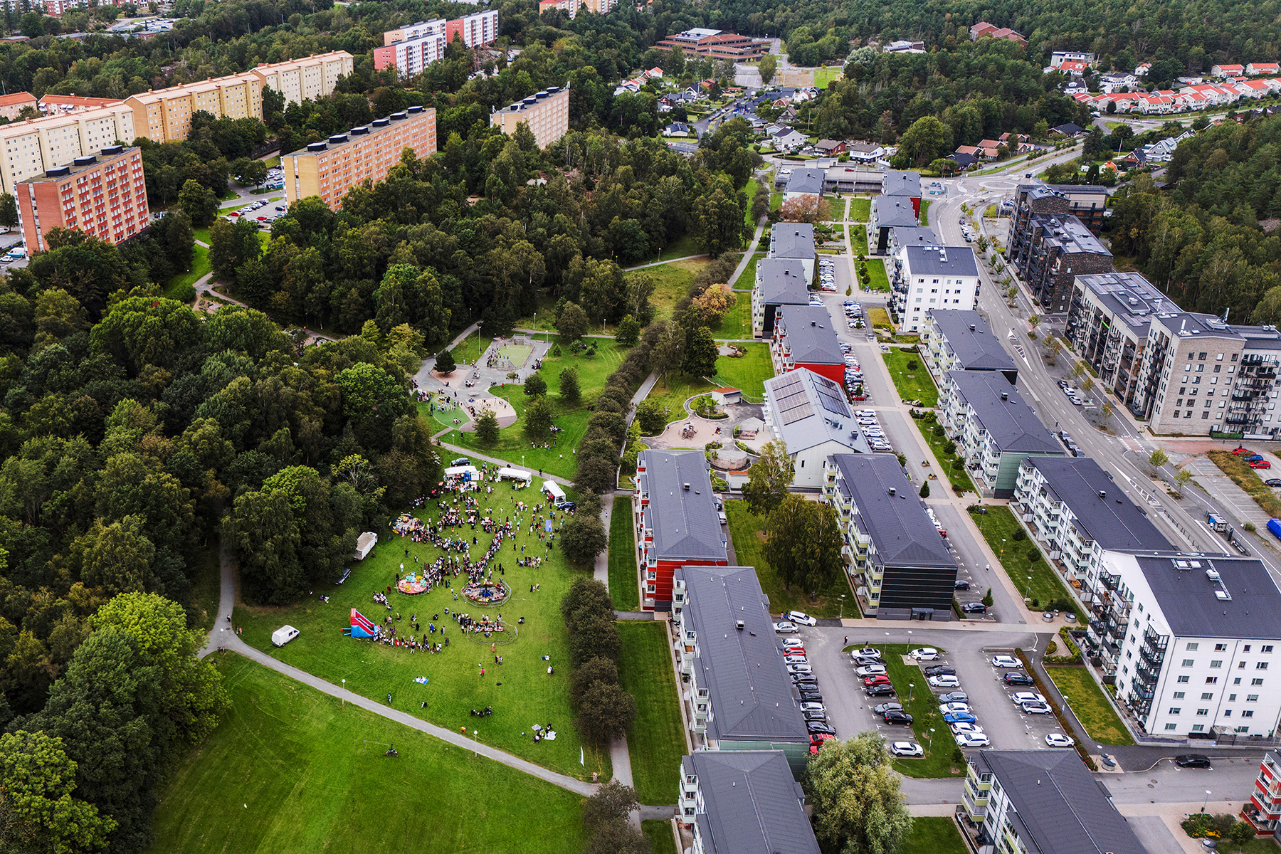Översiktbild på Svartedalen med hus, gräsmattor, träd och människor.