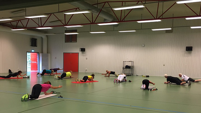 En grupp människor tränar liggande på golvet i Geråshallen. Foto: Malin Jansson
