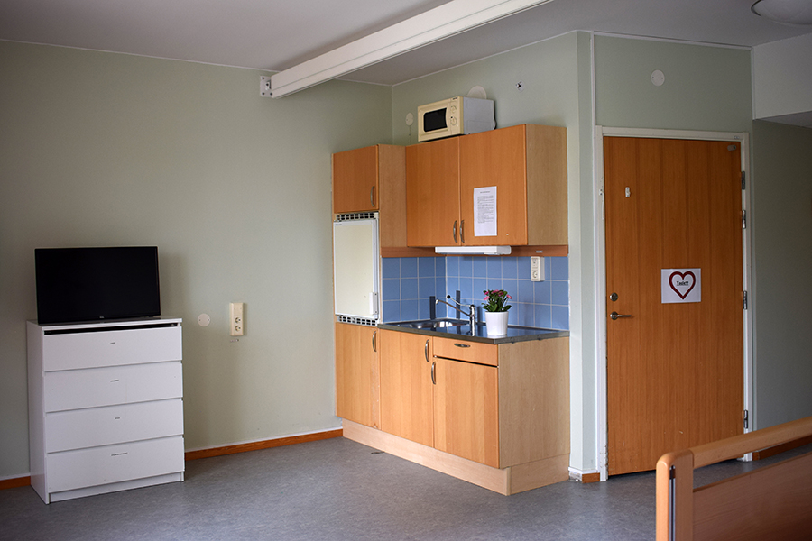 Köksdelen i lägenheten med mikrovågsugn och kylskåp